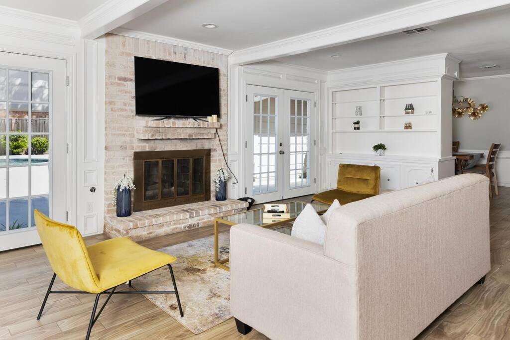 Houston Luxury 4br/3ba and Pool في شوغر لاند: غرفة معيشة مع أريكة بيضاء ومدفأة