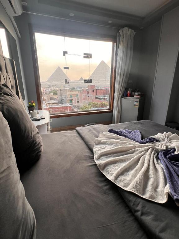 a bed in a bedroom with a large window at Pyramids Hills INN in Cairo