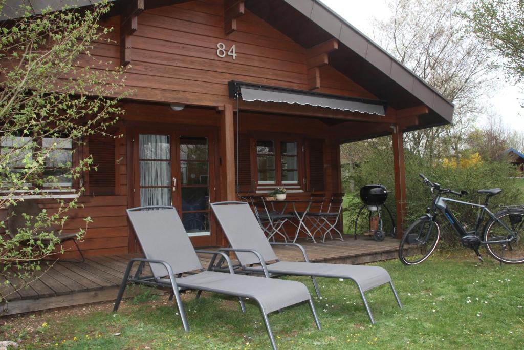a cabin with two chairs and a bike on a deck at Ferienhaus Tauber 84 in Hayingen