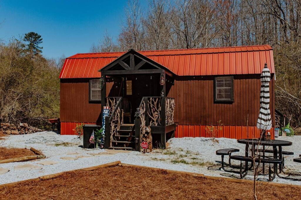 ein kleines Gebäude mit einem roten Dach und einem Picknicktisch in der Unterkunft Lazy Bear Retreat by the Creek in Pickens