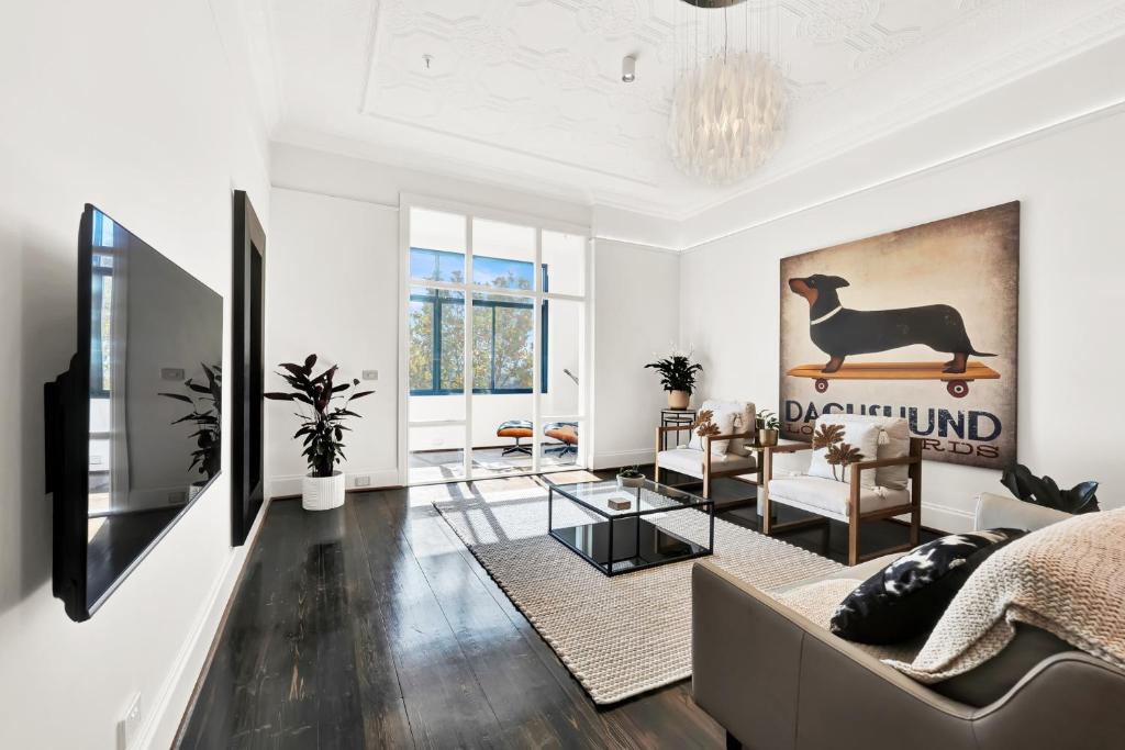 - un salon avec un canapé et une télévision dans l'établissement Paris End of St Kilda Apartment, à Melbourne