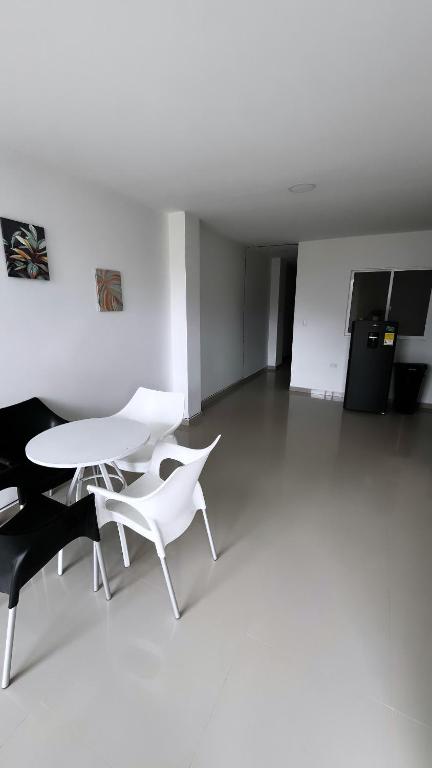 Habitación blanca con 2 sillas y mesa en Apartamento Escalini Pitalito, en Pitalito