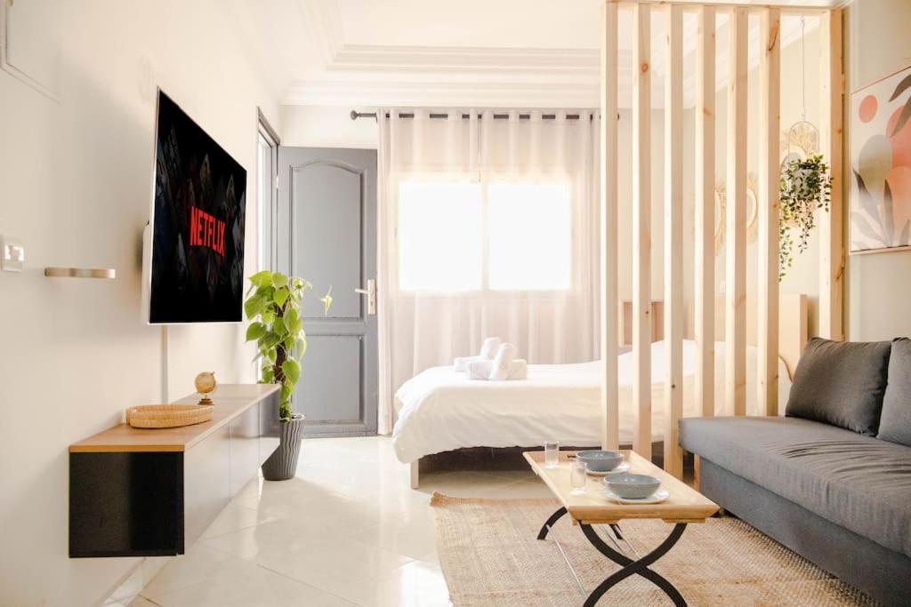 uma sala de estar com uma cama e um sofá em Studio avec Terrasse au Cœur de l'Agdal em Rabat