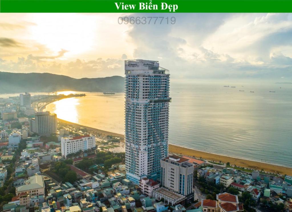 a tall building next to a beach and the ocean at TMS Sea Condotel Quy Nhơn in Quy Nhon