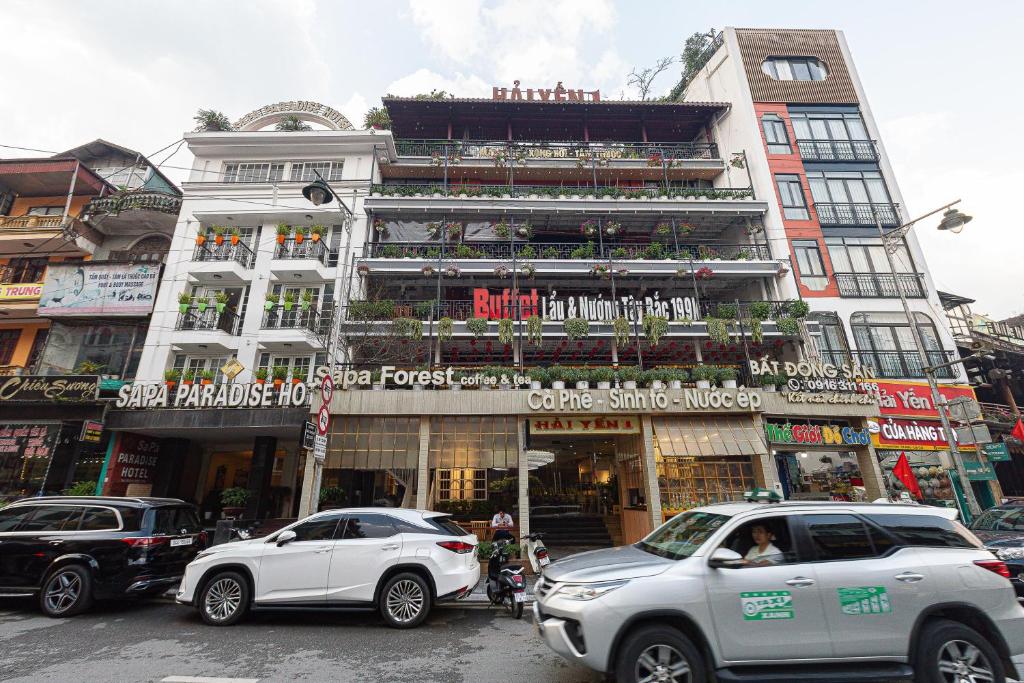 two cars are parked in front of a building at Sapa Hai Yen Hotel and Apartment in Sa Pả
