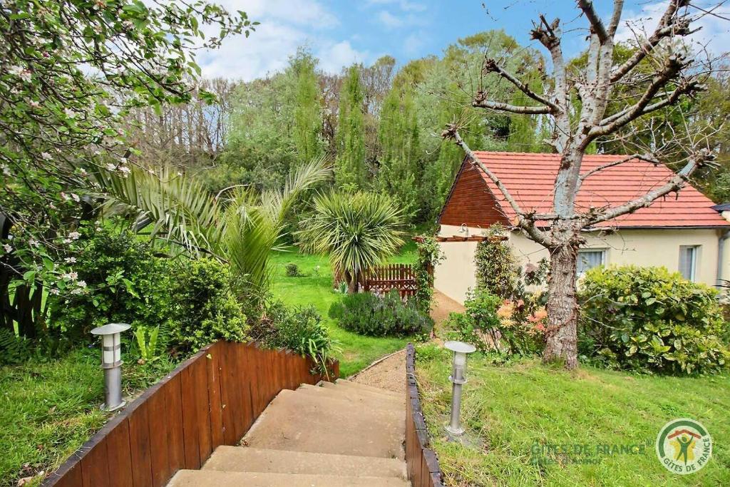 ein Haus mit einem Zaun und einer Treppe in einem Hof in der Unterkunft Au bord du ruisseau in Saint-Quay-Perros