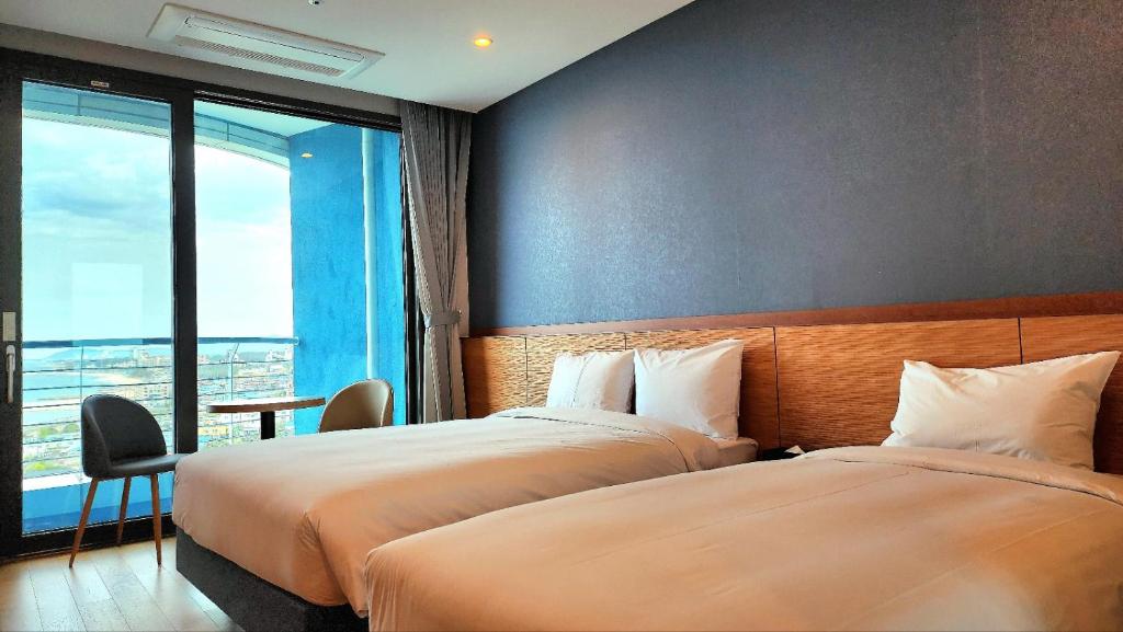 Habitación de hotel con 2 camas y ventana en SL Hotel Gangneung en Gangneung
