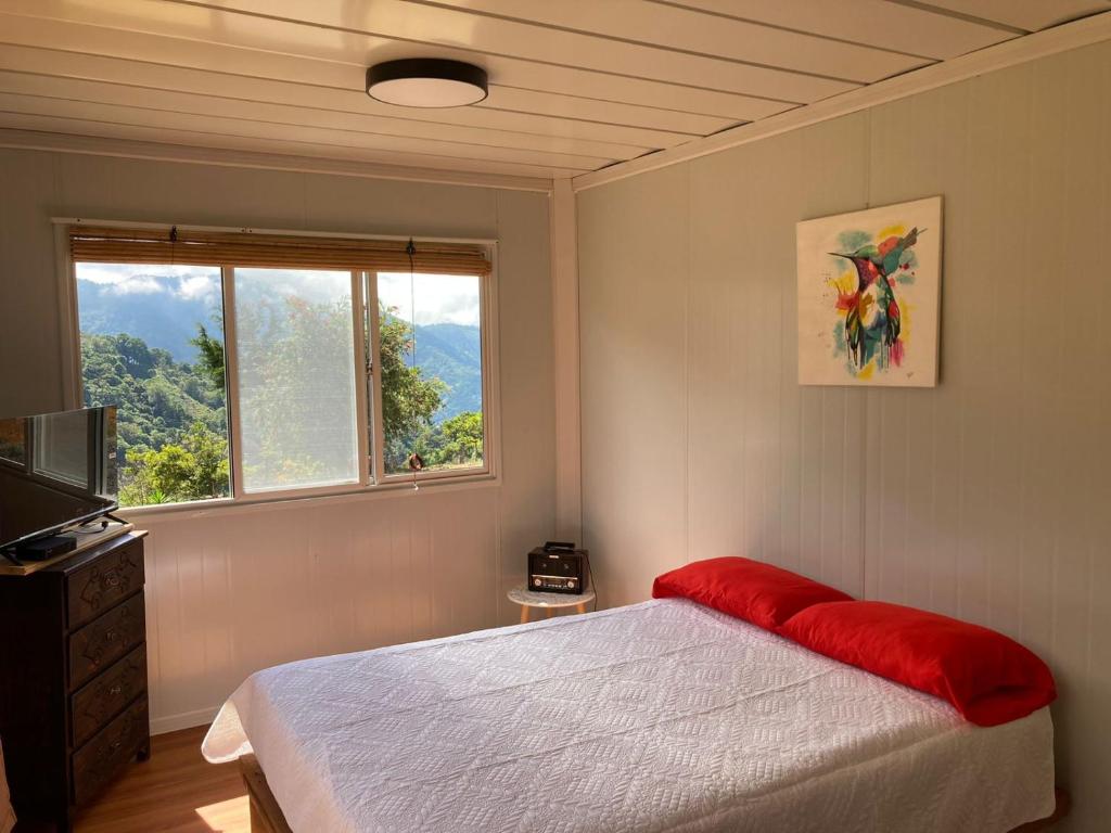 a bedroom with a bed and a window at Mario's Lodge Providencia in El Copey