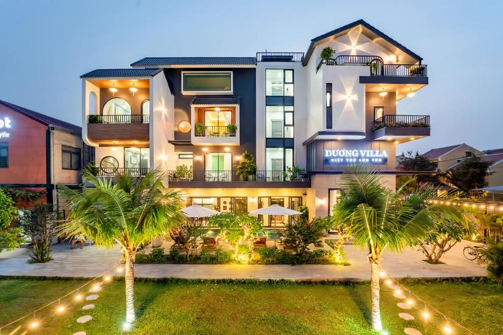 會安的住宿－Villa Dương Hội An，一座棕榈树环绕的大建筑