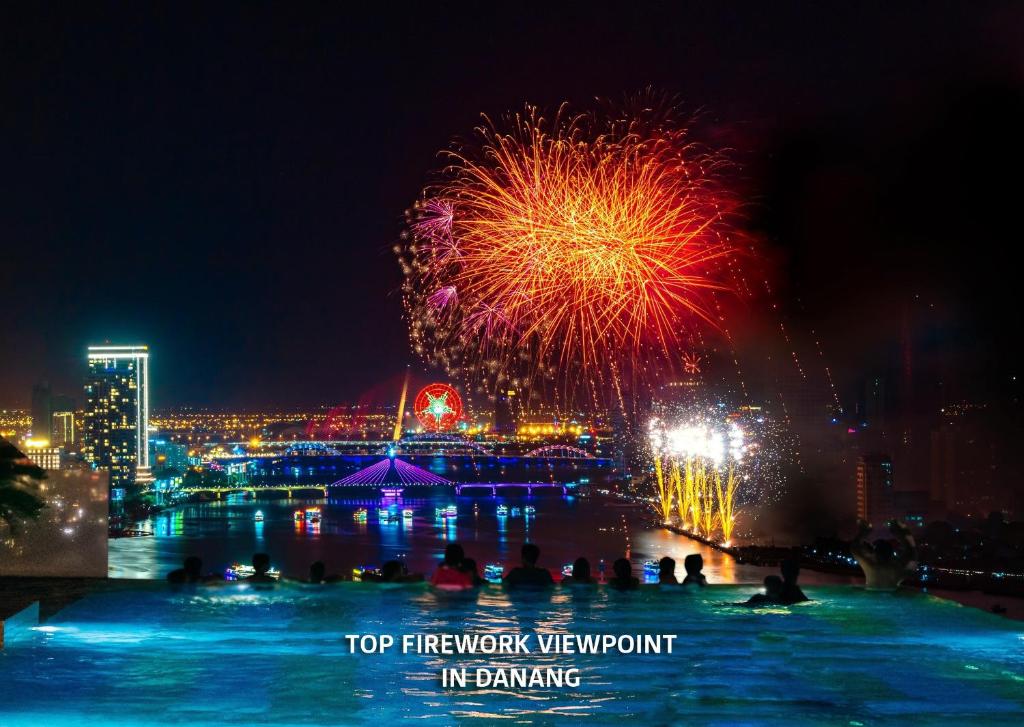 a firework event with people in the water at night at Wyndham Danang Golden Bay in Da Nang