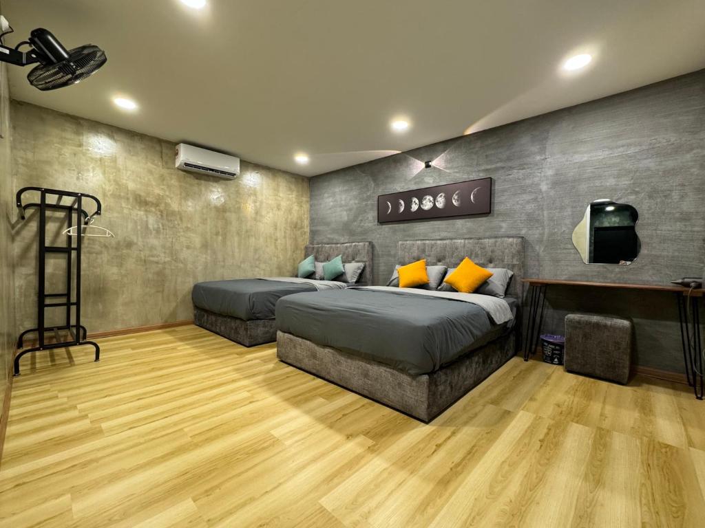 2 Betten in einem Zimmer mit Holzböden in der Unterkunft THEBA's Home樂爸民宿 Pasir Penambang, Kuala Selangor in Kuala Selangor