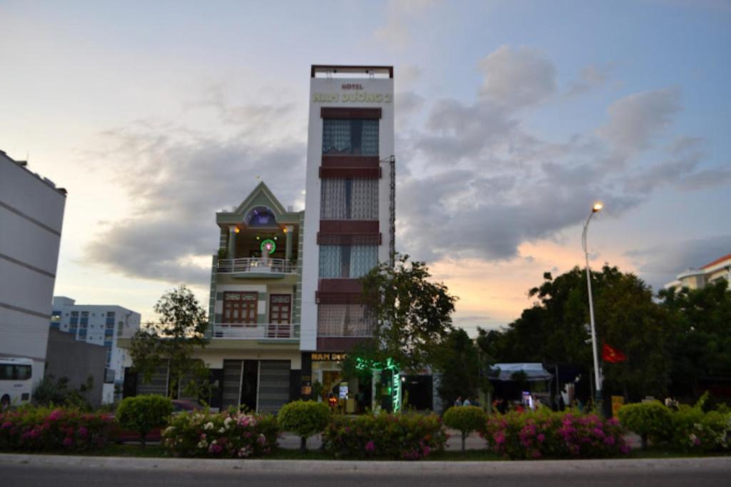 un grand bâtiment avec une horloge en haut dans l'établissement Nam Dương 2 Hotel, à Phan Rang