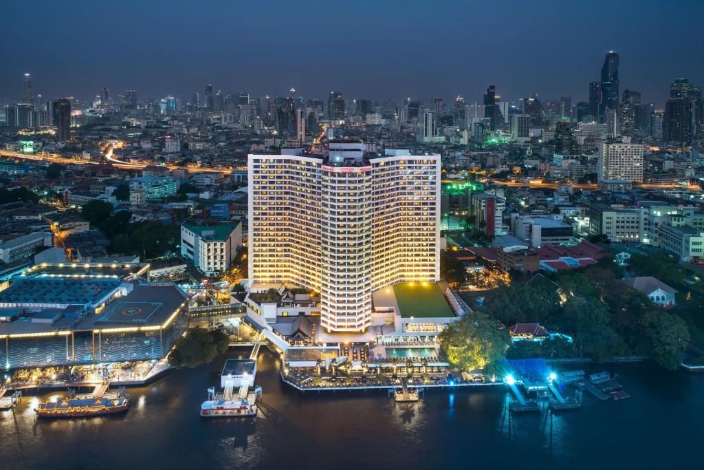 een verlicht gebouw in een stad 's nachts bij Royal Orchid Sheraton Hotel and Towers in Bangkok