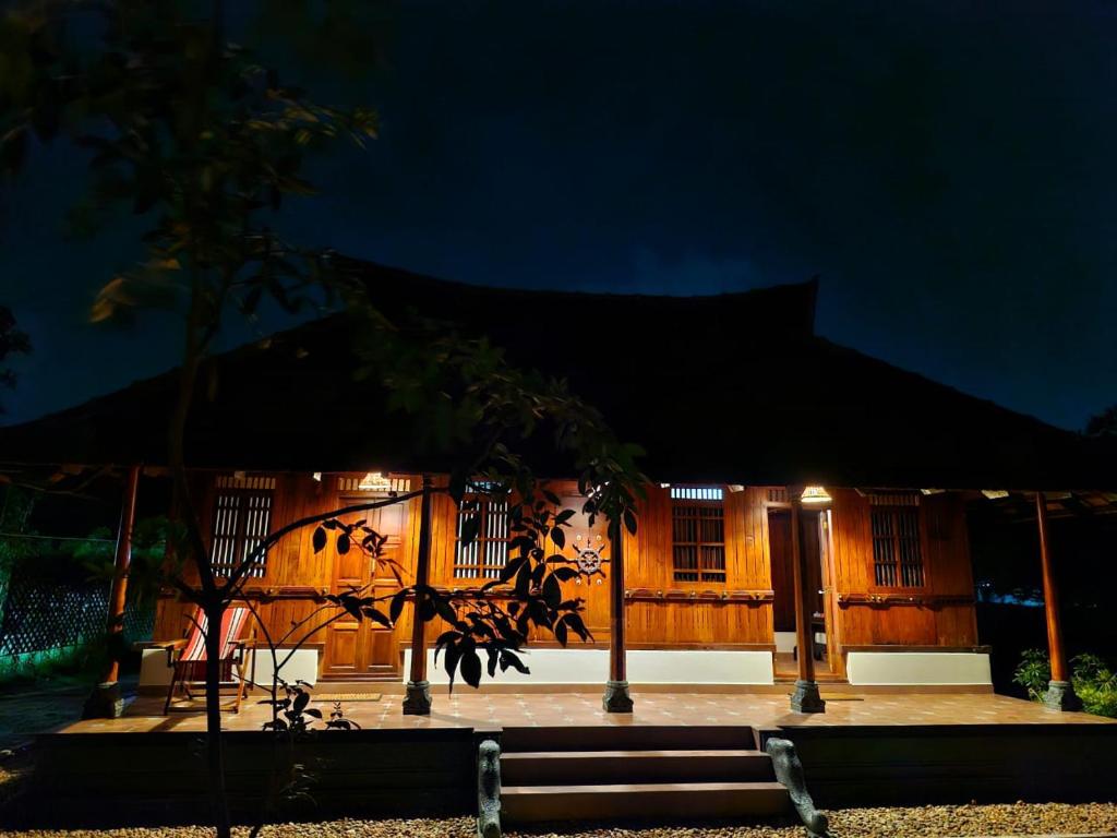 a small house with a lit up facade at night at Gypsea Marari in Alleppey