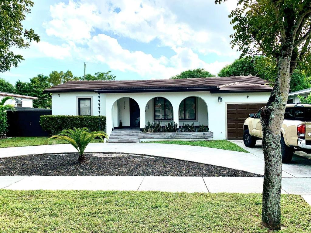 una casa blanca con un coche aparcado delante de ella en WONDERFULL NORTH MIAMI en Miami