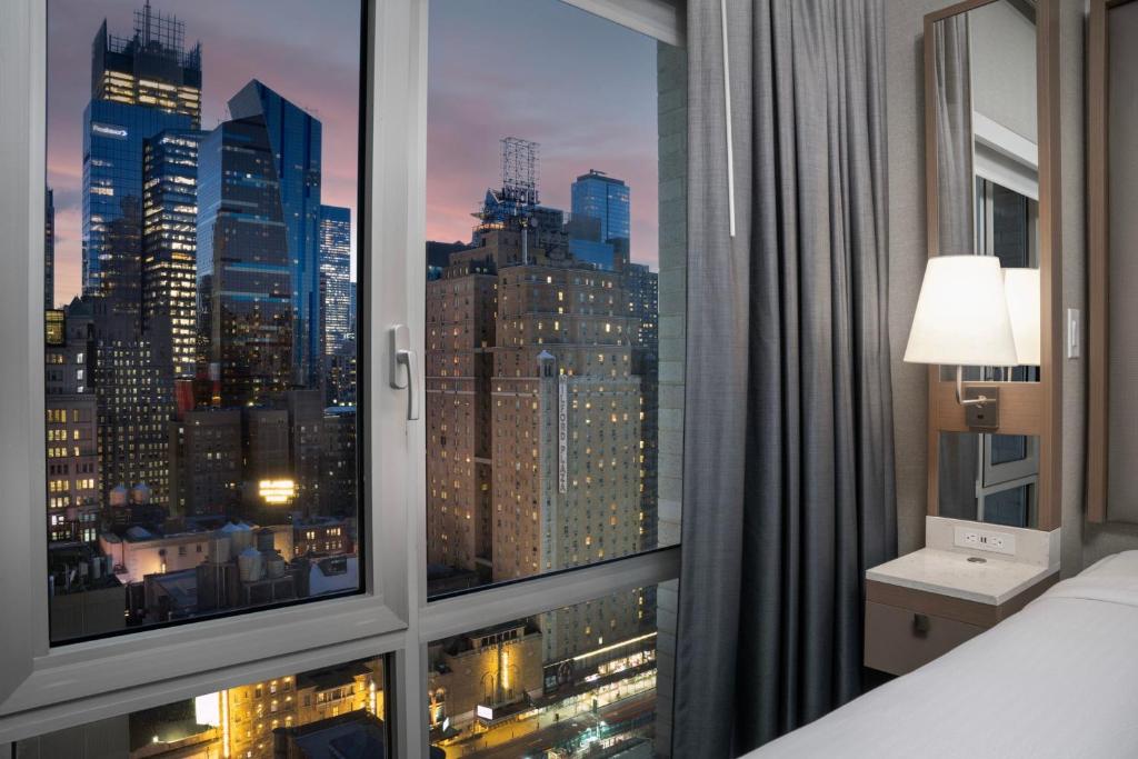 a room with a window with a view of a city at SpringHill Suites by Marriott New York Manhattan Times Square in New York