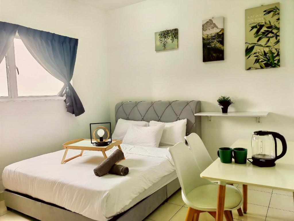 Schlafzimmer mit einem Bett mit einem Tisch und Stühlen in der Unterkunft Alanis Residence Room Sepang KLIA Kota Warisan in Sepang