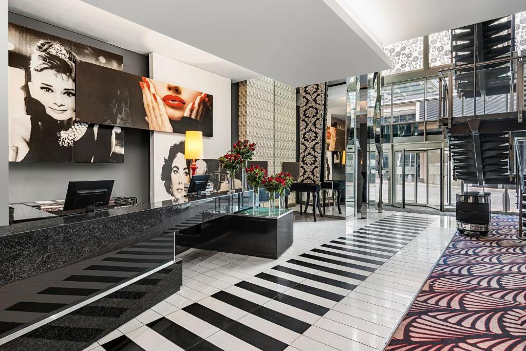 a lobby with a reception desk in a building at Protea Hotel Fire & Ice! by Marriott Johannesburg Melrose Arch in Johannesburg