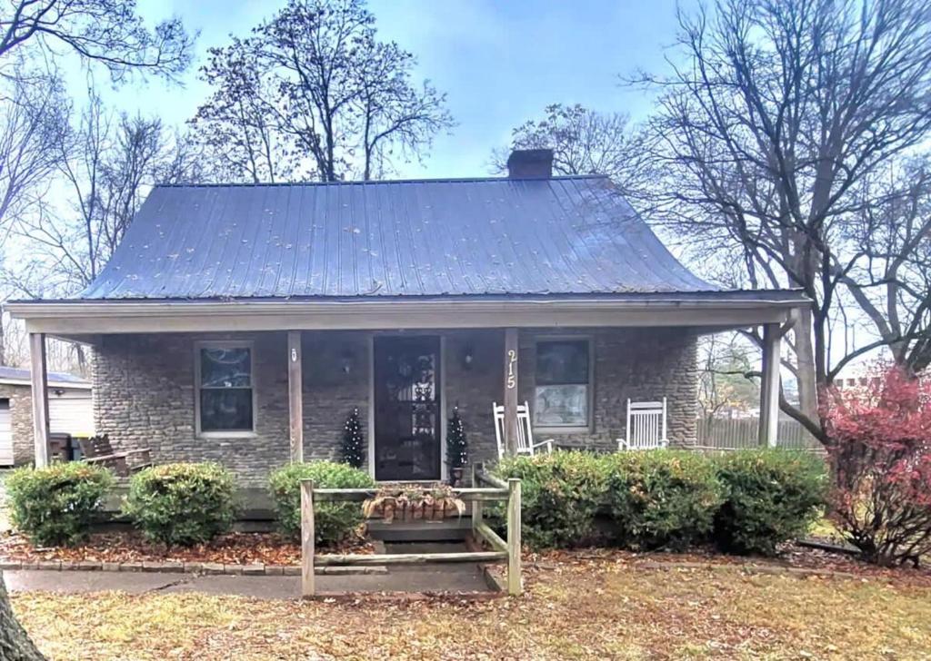 a small brick house with a metal roof at Cozy Cottage in Louisville in Louisville