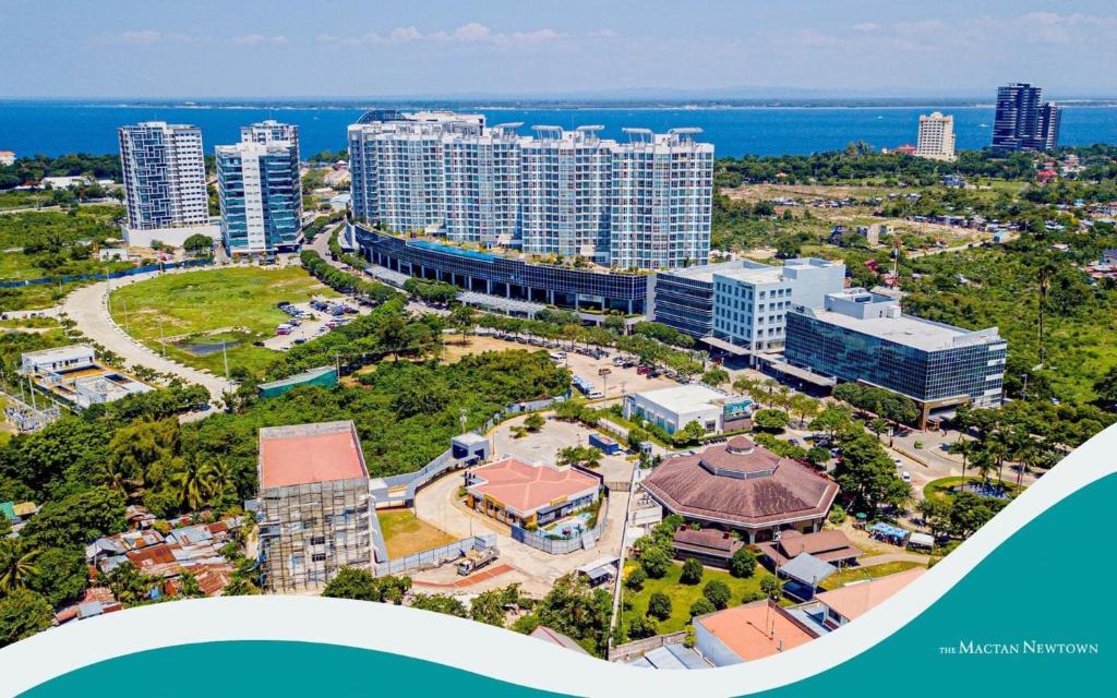 an aerial view of a city with buildings and the ocean at 8 Newtown Boulevard by Hiverooms in Lapu Lapu City