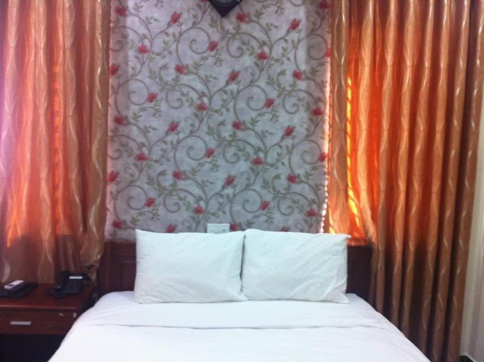 a bedroom with a bed and a wall with a curtain at Khách Sạn Khải Yến in Pleiku
