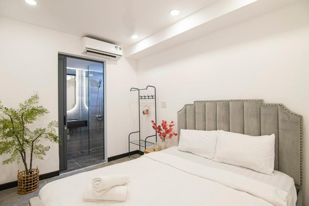 a bedroom with a large bed and a shower at CODOTEL 86 in Ho Chi Minh City