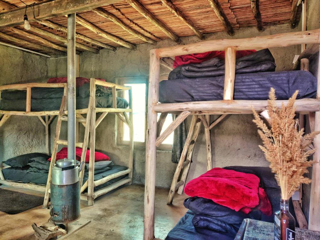 a room with three bunk beds with red and blue blankets at Spiti Eco Domes in Kaza