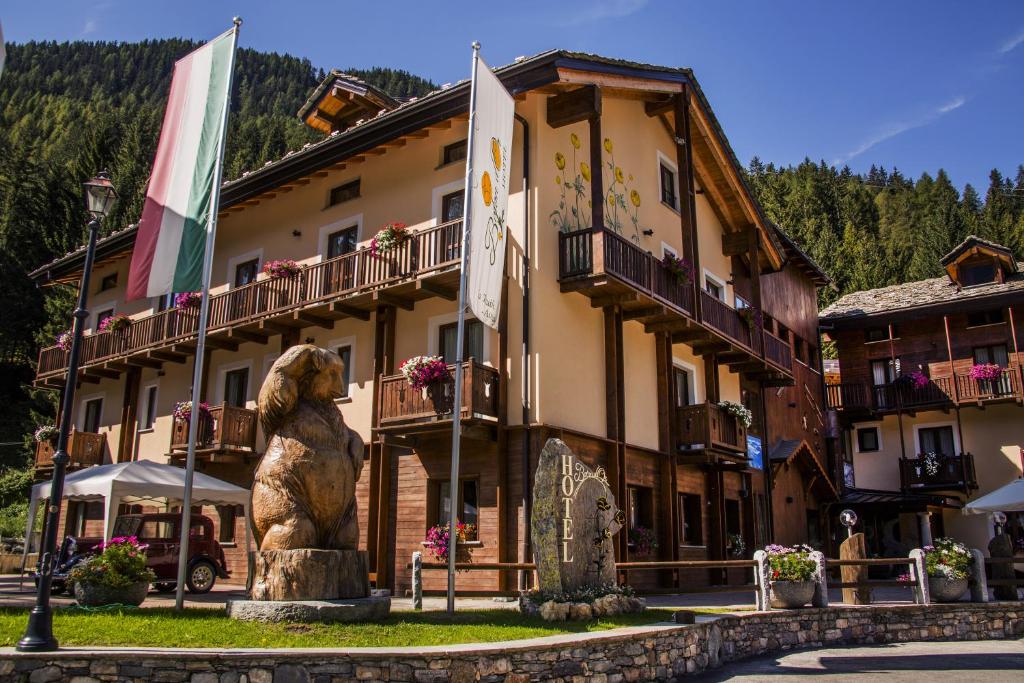 a large building with a statue in front of it at Hotel Boton D'Or & Wellness in La Thuile