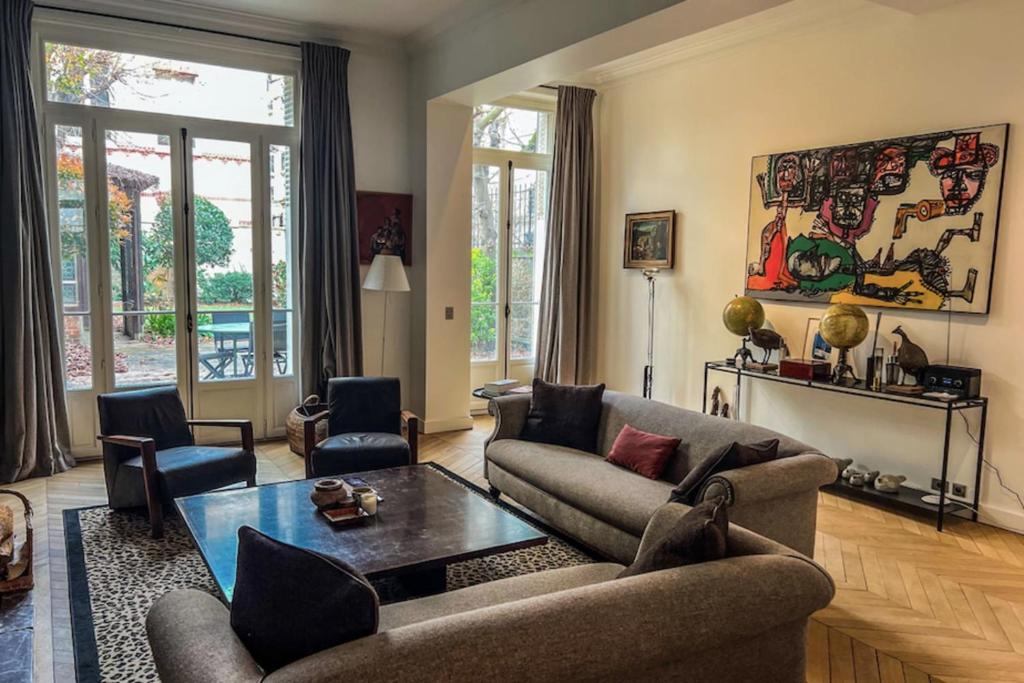 - un salon avec un canapé et une table dans l'établissement Atypical house with garden, à Paris