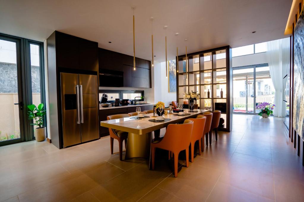 a kitchen with a large dining table and orange chairs at Regal Victoria luxury villa in Trà Khê (1)