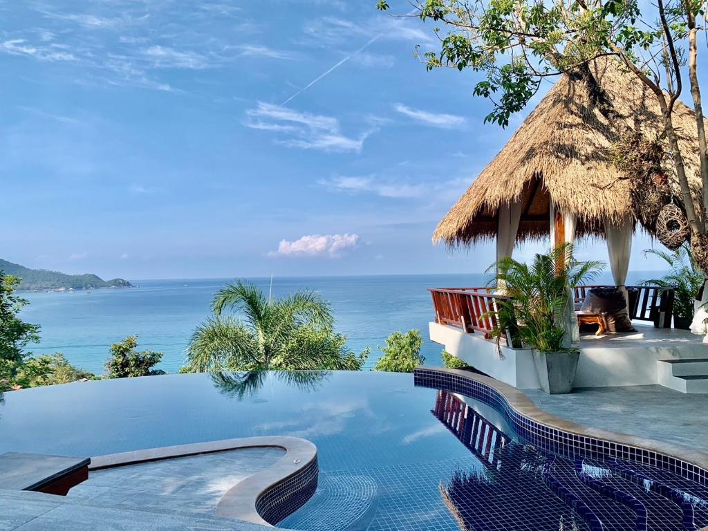 an infinity pool with a view of the ocean at Kohtao Heritage Hideaway in Ko Tao