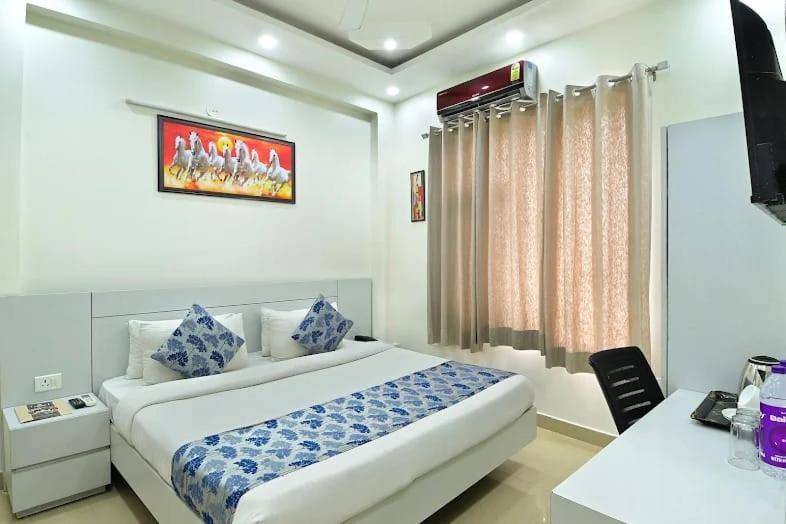 a hotel room with a bed and a desk and a television at the indigo premium in Noida