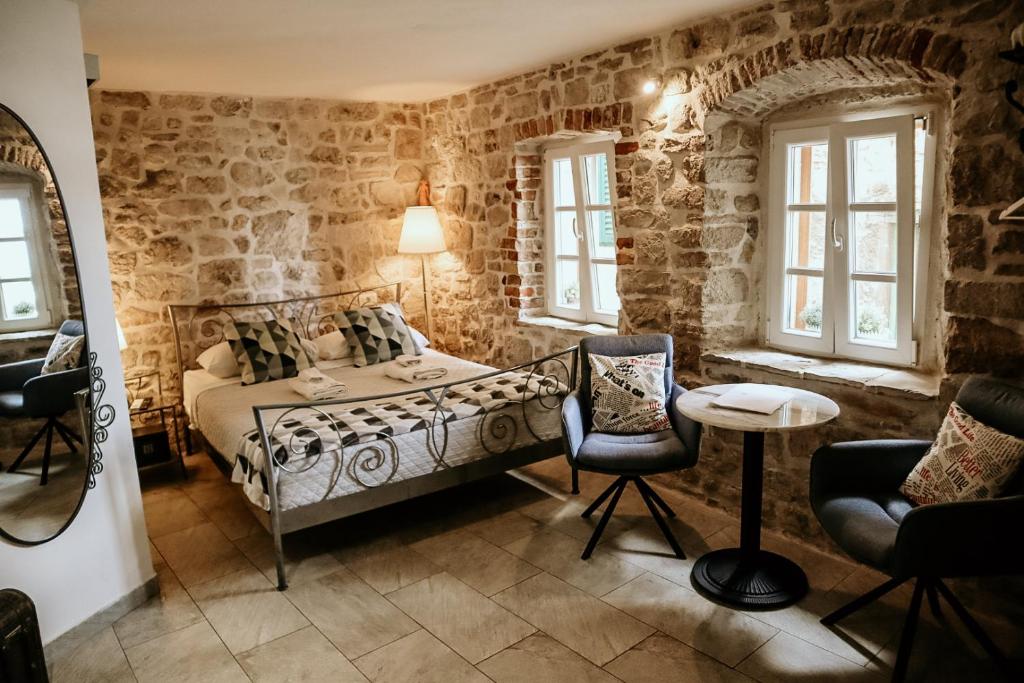 um quarto com uma cama, uma mesa e cadeiras em City Rooms Šibenik em Sibenik