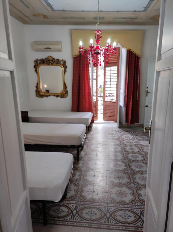 a room with beds and a mirror and a corridor at Casa Giannina in Palermo