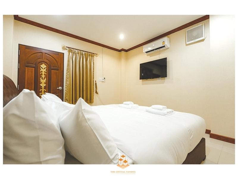 sypialnia z dużym białym łóżkiem i telewizorem w obiekcie The Crystal Ranong No101 w mieście Ban Lum Than