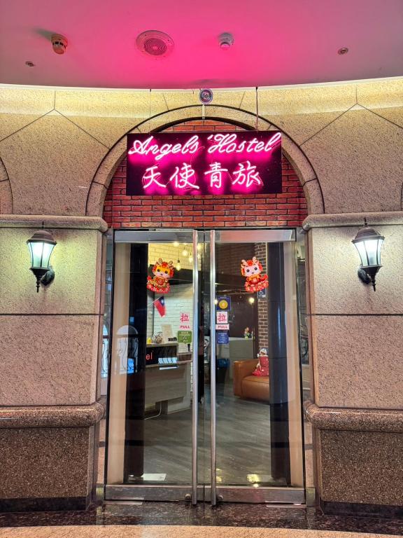 a building with a sign on the entrance to a store at Angels Hostel Taipei Ximen in Taipei