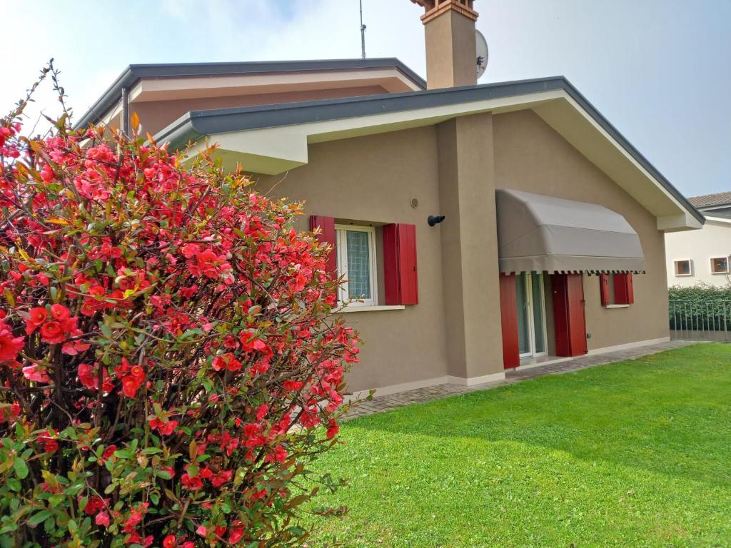 Arcade的住宿－Casa vacanze La Madonnetta，院子里有红色花的小房子