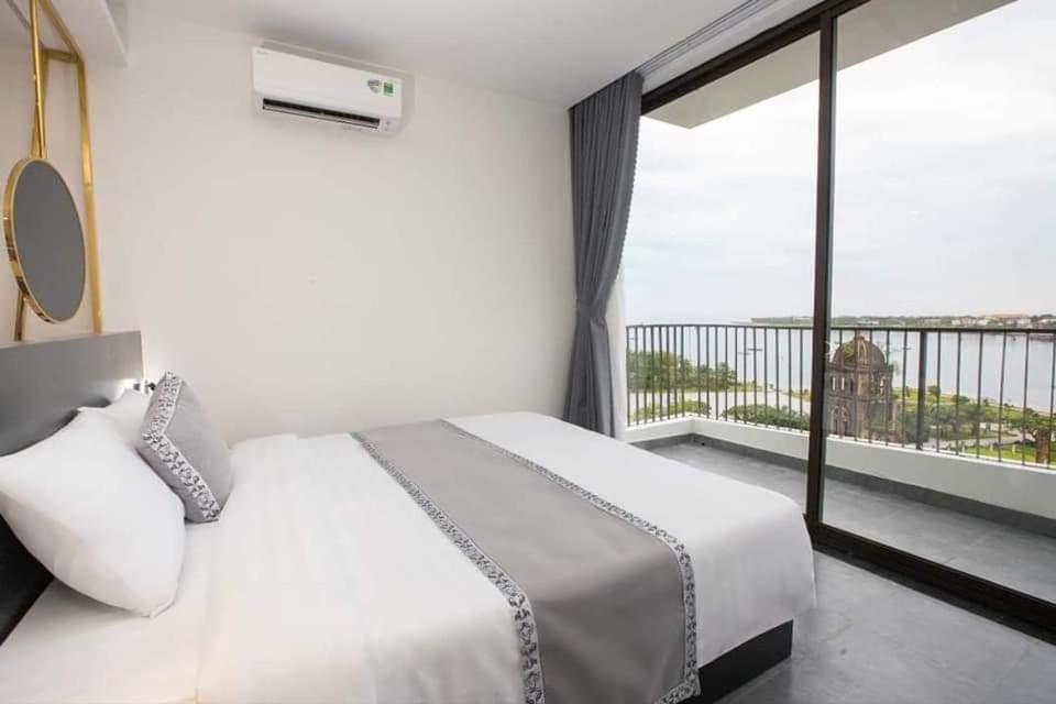 1 Schlafzimmer mit einem weißen Bett und einem Balkon in der Unterkunft Clover Home Đồng Hới in Dong Hoi