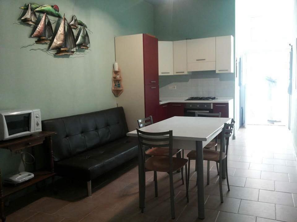 a kitchen with a black couch and a table and chairs at Casa Sisse in Càbras
