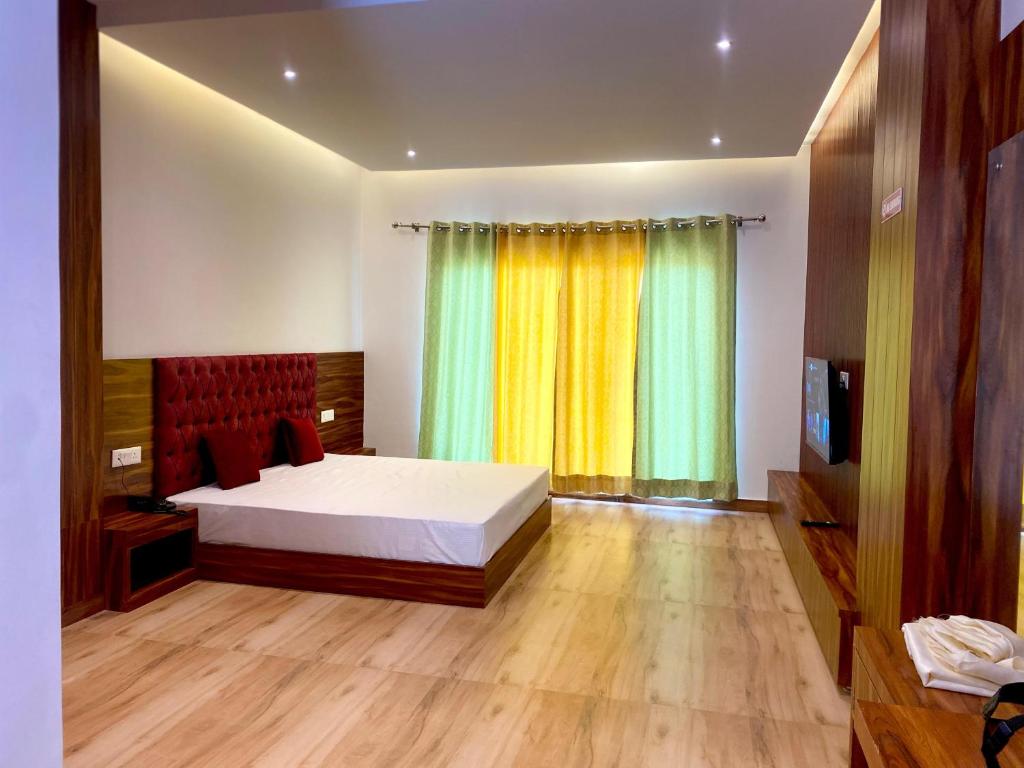 1 dormitorio con cama y ventana grande en Jamunas B&B, en Shimla