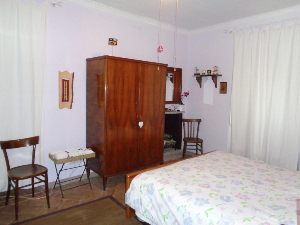 グランドラ・エドゥニーティにあるB&B Casa Del Soleのベッドルーム1室(ベッド1台付)、木製キャビネットが備わります。