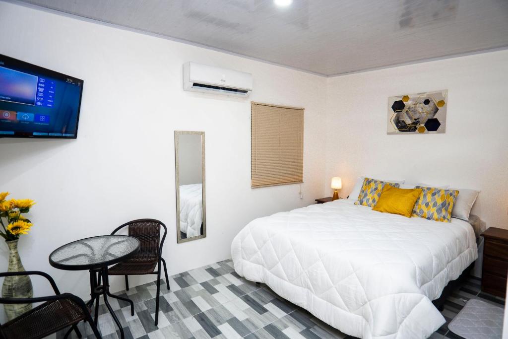 1 dormitorio con cama, mesa y TV en Casa Nella, en Tamarindo