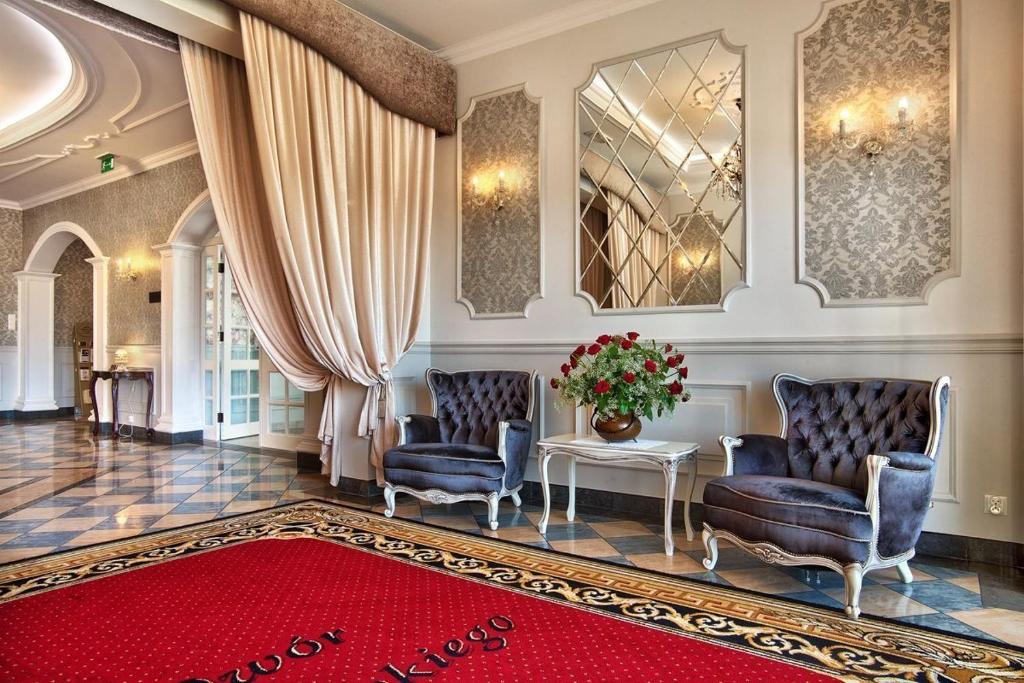 a living room with two chairs and a red rug at Dwór Czarneckiego in Białystok