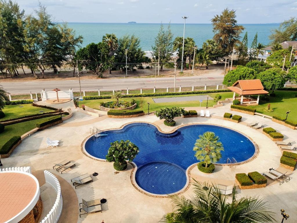 una vista aérea de una piscina con sillas y el océano en Seaview Condo B63, en Mae Pim