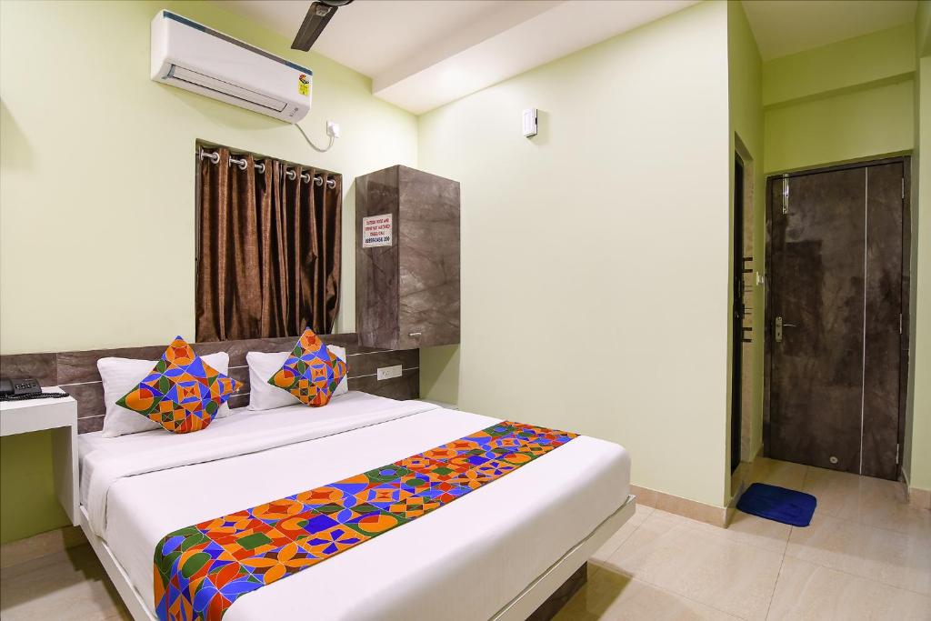 a bedroom with a bed with a colorful blanket on it at FabHotel The Sunshine Residency in Kolkata