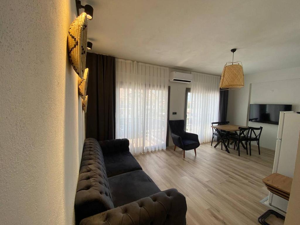 a living room with a couch and a dining room at Aden Apart Otel in Fethiye