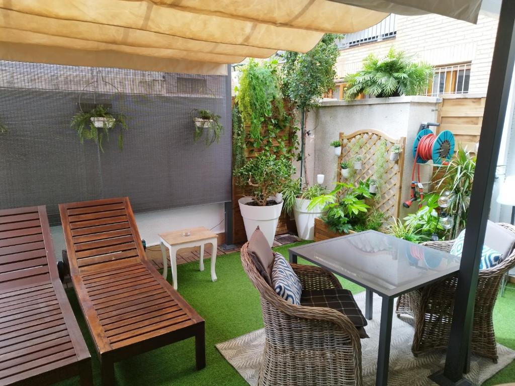 un patio al aire libre con mesa, sillas y plantas en APARTMENT BIG PRIVAT TERRACE CALAFELL BEACH FREE Parking, en Calafell