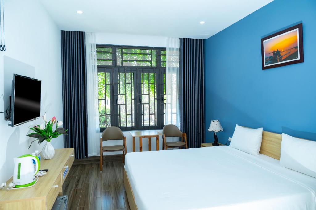um quarto de hotel com uma cama grande e uma janela em BLUE SEA Motel em Thăng Bình