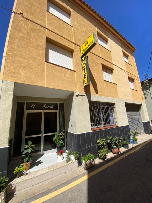 un immeuble avec un panneau de location devant lui dans l'établissement Hotel El Pescador, à Sant Pere Pescador