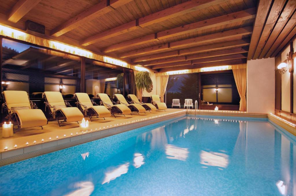 a swimming pool in a hotel with lounge chairs at Boutiquehotel Säumler in Zell am Ziller